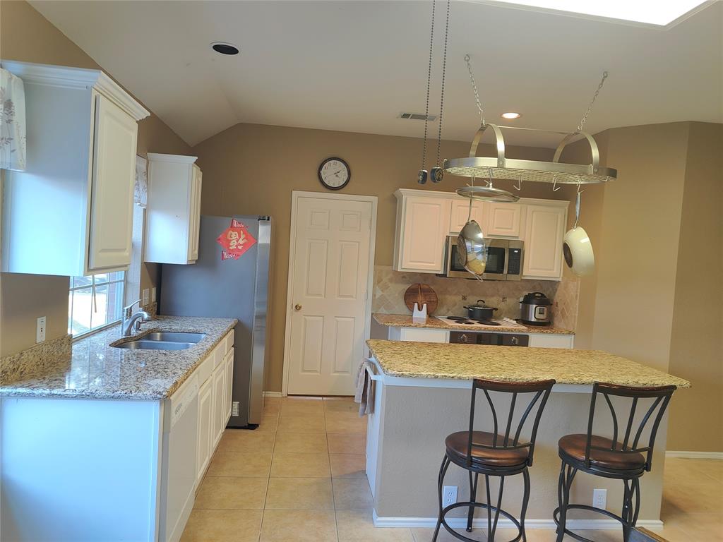 7900 Roaring Ridge Drive Plano, TX 75025 - Photo 10 of 34 a kitchen with a sink a stove cabinets and counter space