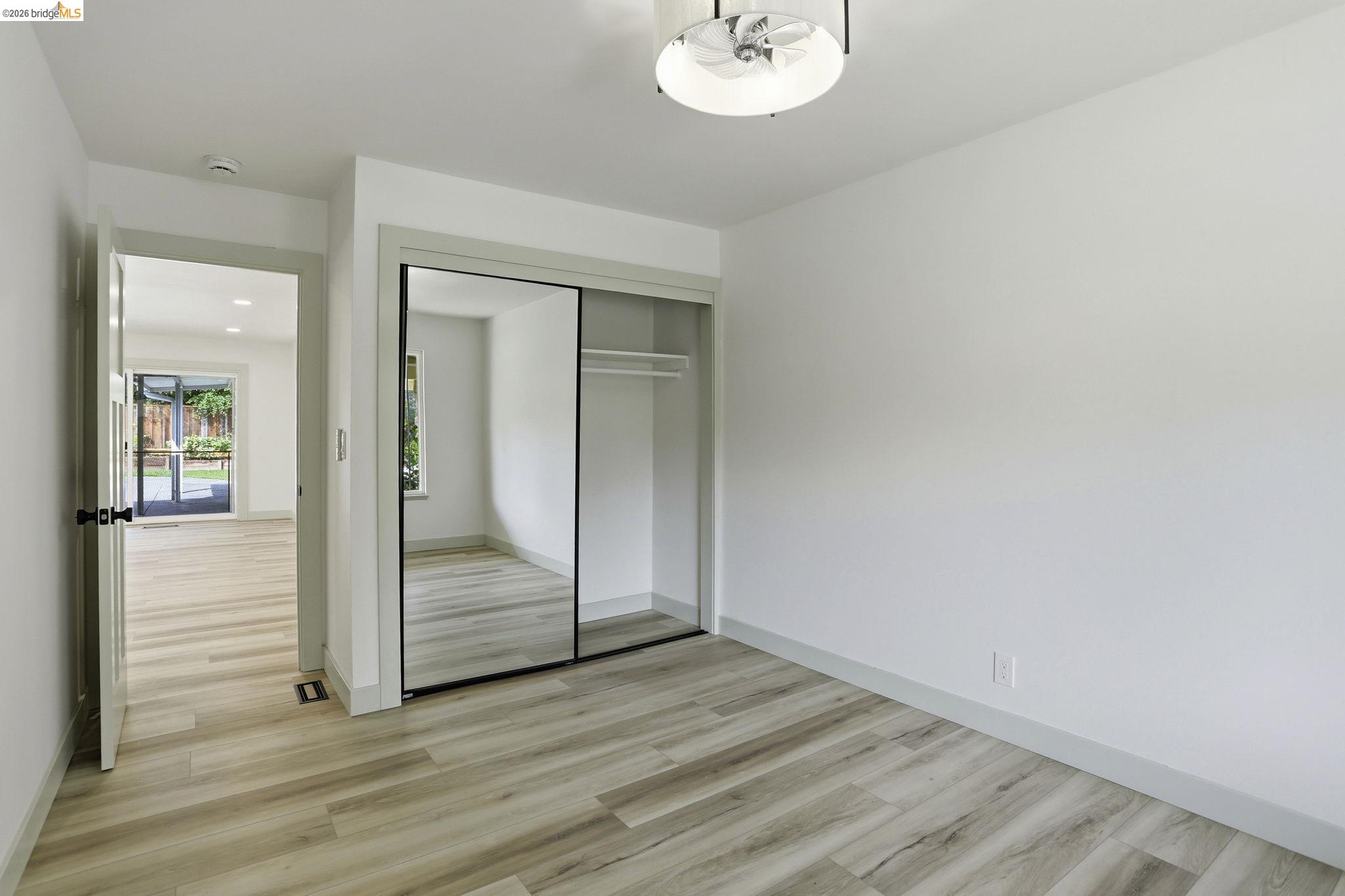 2438 Merritt Place Livermore, CA 94550 - Photo 25 of 64 an empty room with wooden floor mirror and window