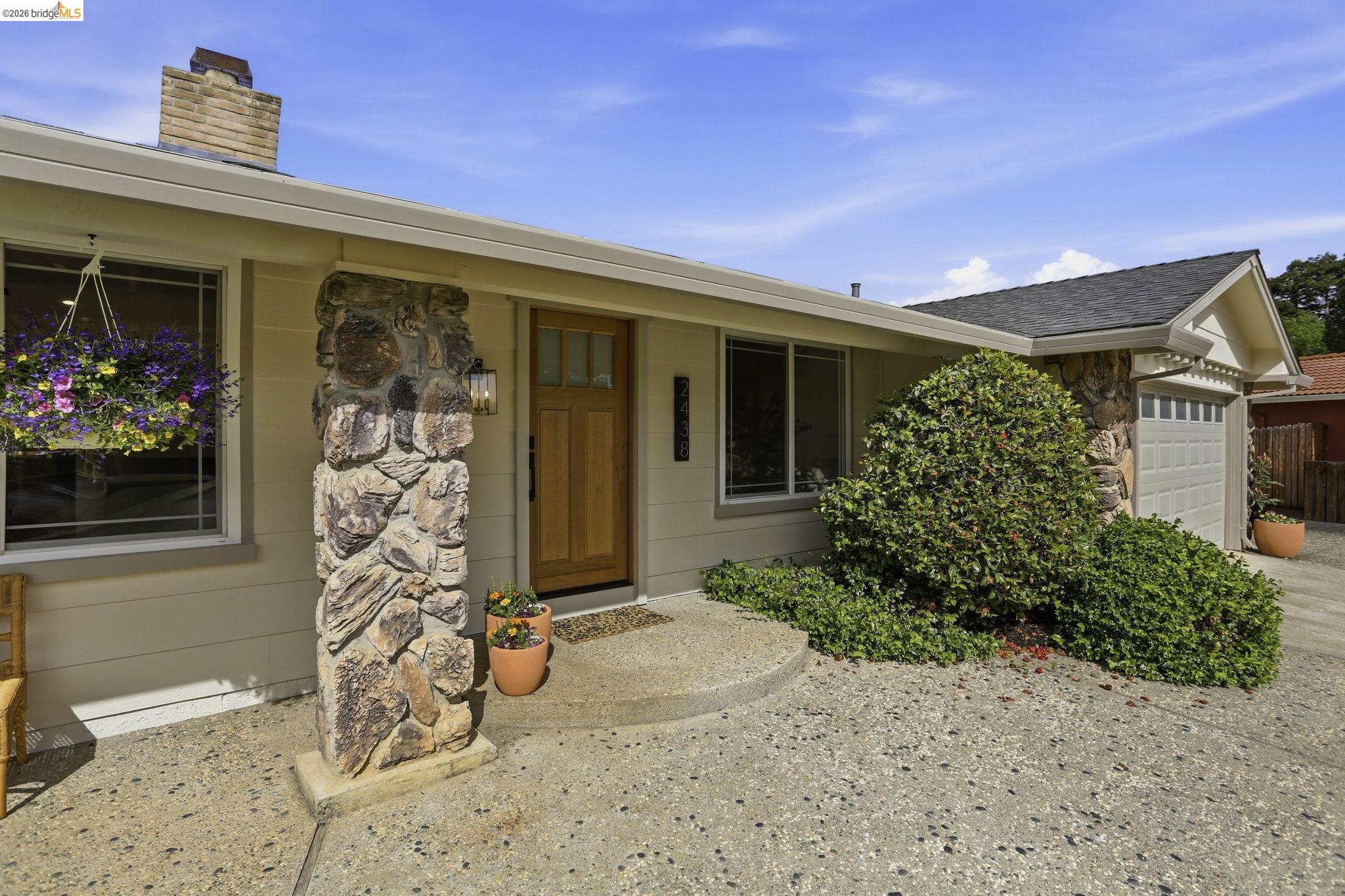 2438 Merritt Place Livermore, CA 94550 - Photo 5 of 64 View of exterior entry with an attached garage, a chimney, and stone siding