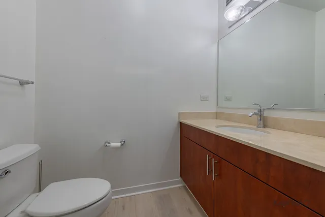 a bathroom with a granite countertop sink a toilet and a mirror