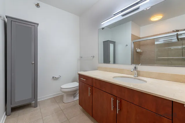 a bathroom with a granite countertop toilet a sink and a mirror
