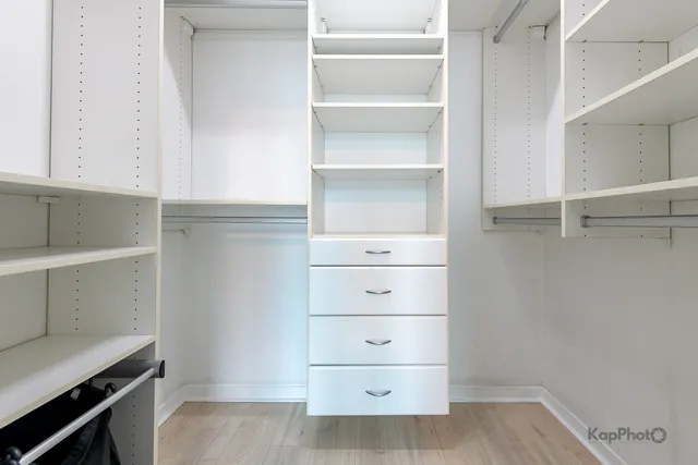 a view of walk in closet with empty racks