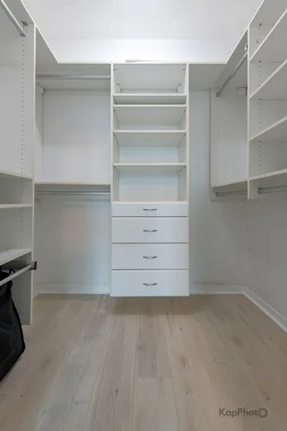 a view of walk in closet with empty racks