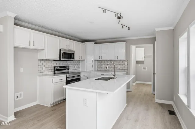 a kitchen with a sink a stove a microwave and refrigerator