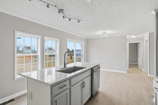 a kitchen with granite countertop a sink and white cabinets
