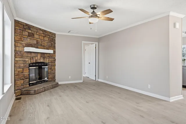 a view of an empty room with a fireplace and a window