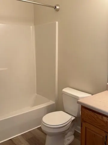 a white toilet sitting next to a bath tub