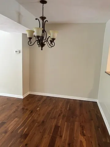 a view of a room with wooden floor and ceiling fan