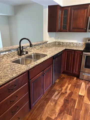 a kitchen with granite countertop a sink and wooden cabinets