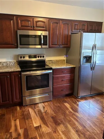 a kitchen with wooden cabinets and stainless steel appliances
