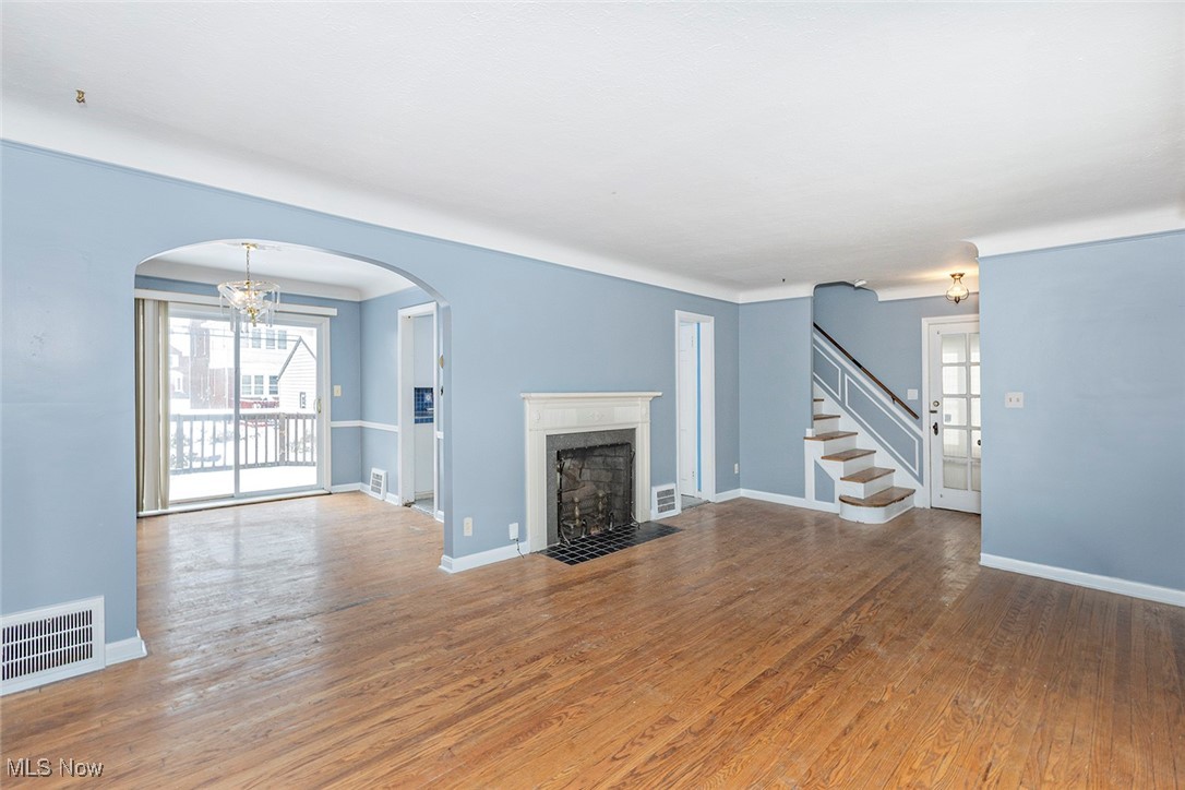 3719 Berkeley Road Cleveland Heights, OH 44118 - Photo 15 of 44 Unfurnished living room featuring a chandelier, wood finished floors, plenty of natural light, and arched walkways