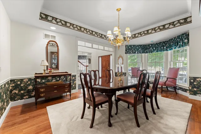 a kitchen with stainless steel appliances granite countertop a stove a sink dishwasher a refrigerator white cabinets wooden floor and a fireplace