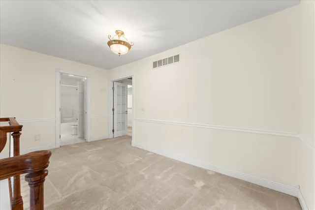 en empty room with windows and chandelier