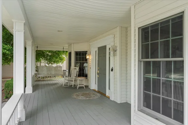 a view of a hallway with wooden floor and furniture