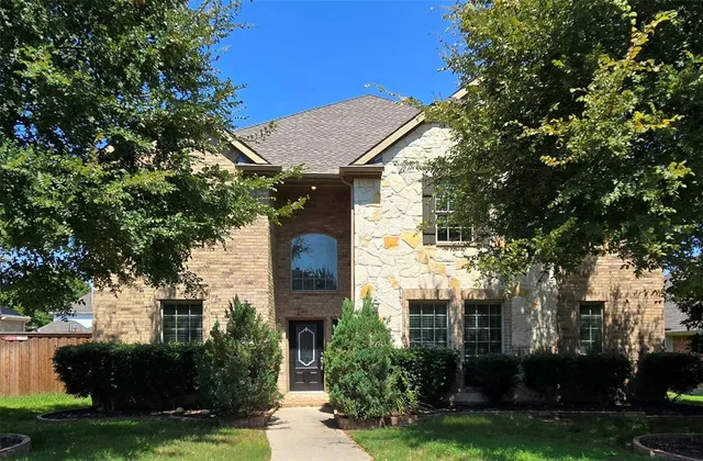 a front view of a house with a yard and trees