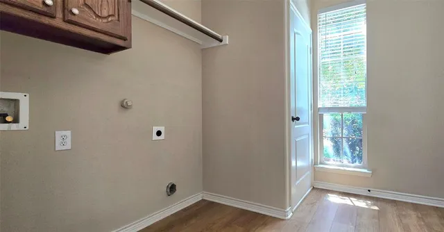 a view of a small space with wooden floor and a window