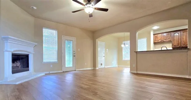 a view of a livingroom with wooden floor and a ceiling fan