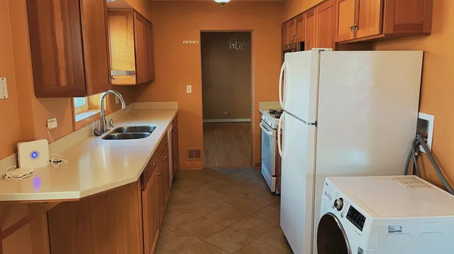 a utility room with refrigerator and washer