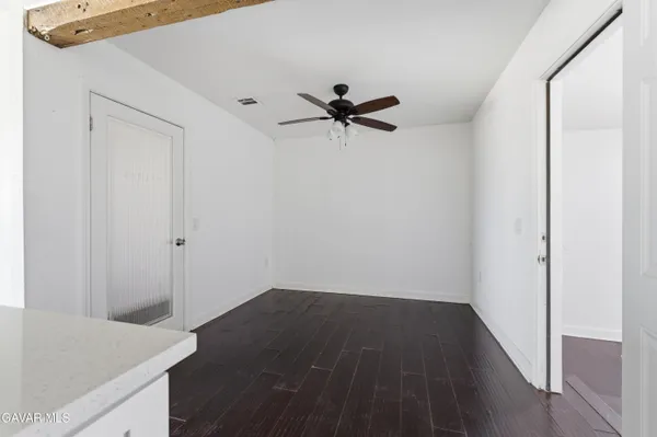 a view of a hallway with a chandelier fan and wooden floor