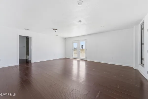 a view of empty room with wooden floor and windows