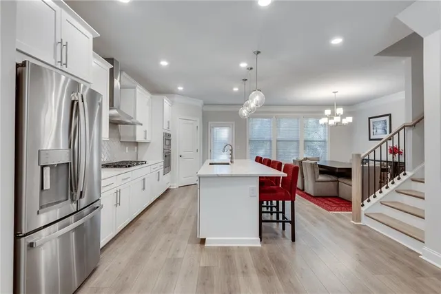 a kitchen with stainless steel appliances granite countertop a refrigerator and a stove top oven
