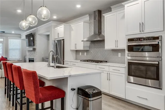 a kitchen with stainless steel appliances a stove a table and chairs