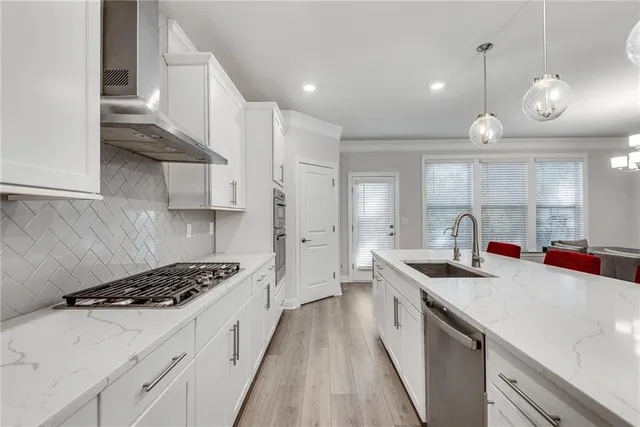 a kitchen with stainless steel appliances a sink stove and cabinets