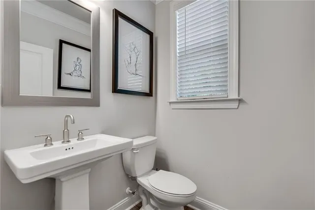 a bathroom with a toilet a sink and mirror
