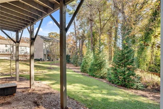 a view of backyard with large trees and plants