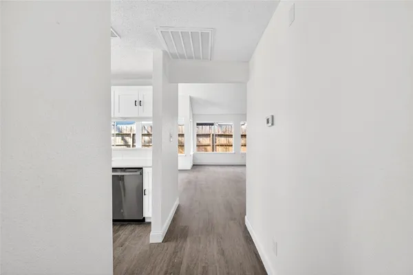 a view of a kitchen from the hallway with a window
