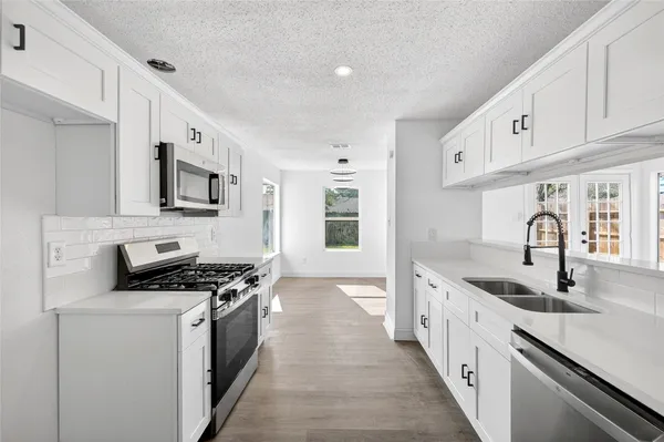a kitchen with stainless steel appliances granite countertop a sink stove and cabinets