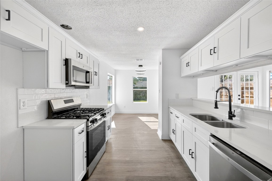 24007 Landing Way Drive Spring, TX 77373 - Photo 15 of 44 a kitchen with stainless steel appliances granite countertop a sink stove and cabinets