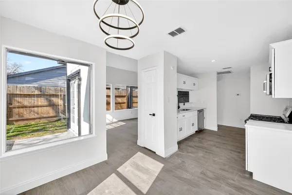 a kitchen with stainless steel appliances a white stove top oven cabinets and a window