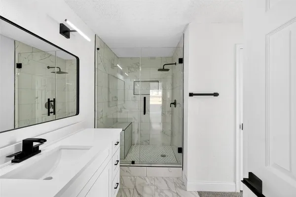a view of an empty room with a window and kitchen view