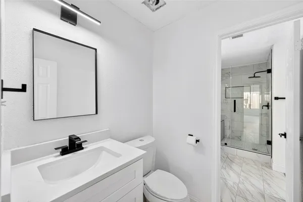 a bathroom with a toilet a sink and a mirror