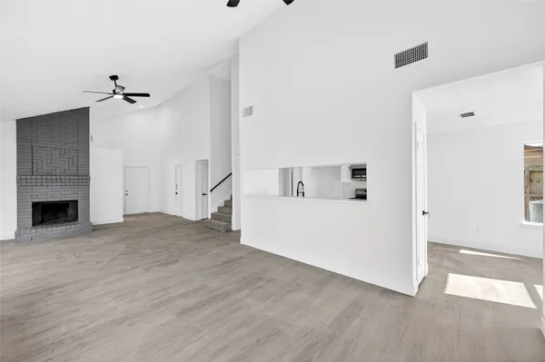 a view of a room with wooden floor and a ceiling fan