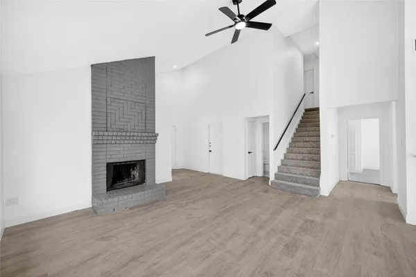 a view of empty room with wooden floor and fireplace