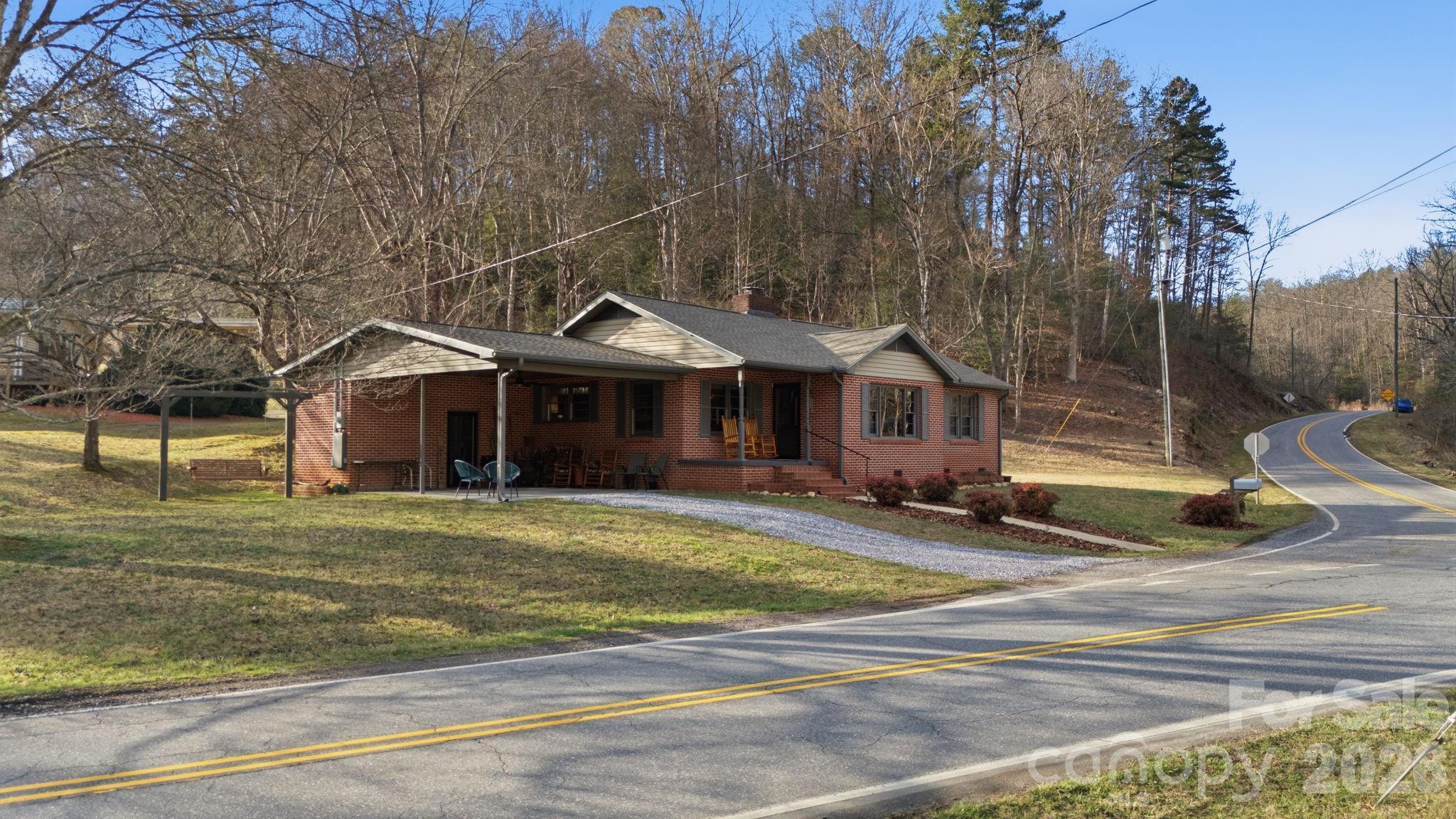 504 Greens Creek Road Sylva, NC 28779 - Photo 1 of 47 a front view of a house with a yard table and chairs