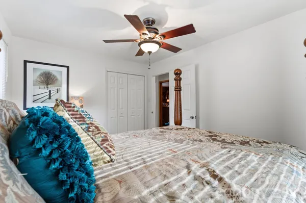 a bedroom with a large bed and a chandelier