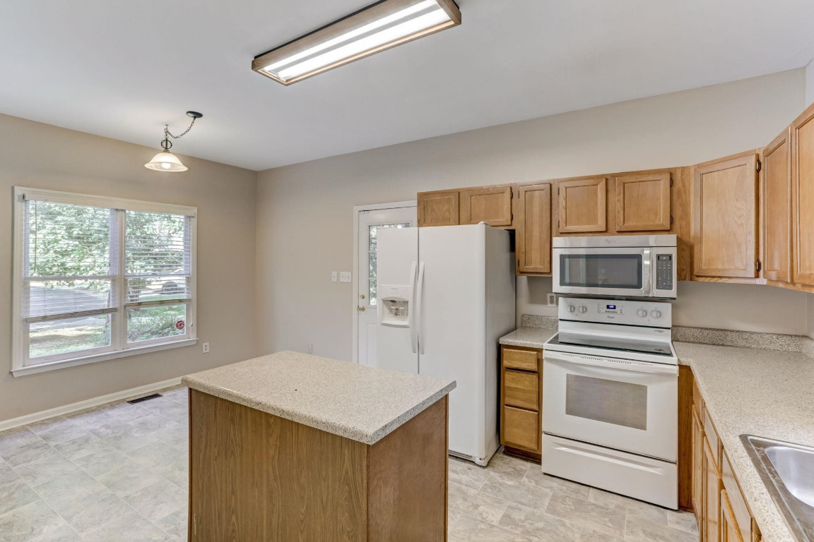 1601 Lethbridge Court Raleigh, NC 27606 - Photo 6 of 17 a kitchen with a refrigerator stove and microwave