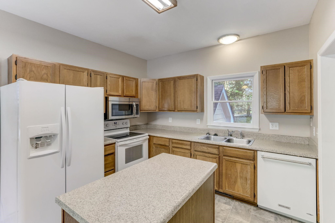 1601 Lethbridge Court Raleigh, NC 27606 - Photo 8 of 17 a kitchen with stainless steel appliances granite countertop a refrigerator sink stove microwave and cabinets