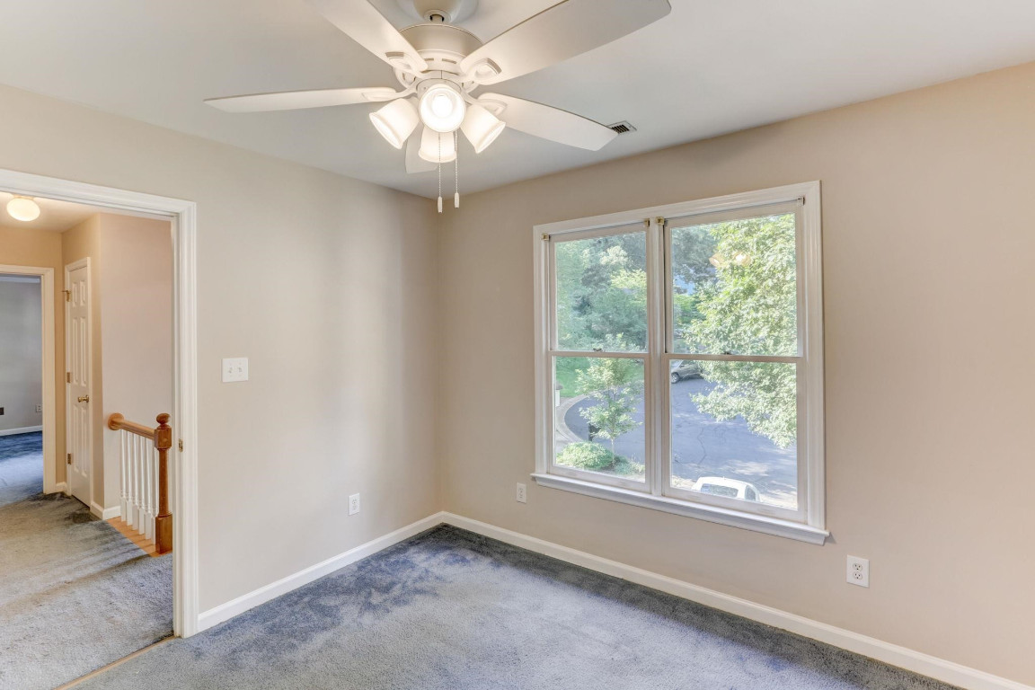 1601 Lethbridge Court Raleigh, NC 27606 - Photo 9 of 17 an empty room with chandelier fan and windows