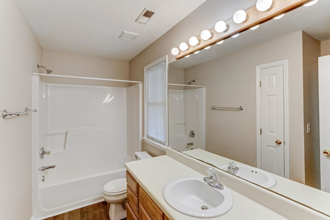 1601 Lethbridge Court Raleigh, NC 27606 - Photo 10 of 17 a bathroom with a sink a toilet a mirror and shower