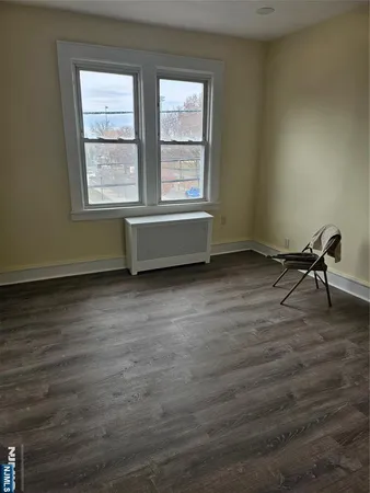 a room with wooden floor and windows