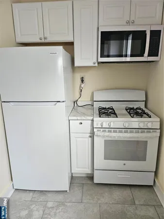 a kitchen with stainless steel appliances white cabinets and a refrigerator
