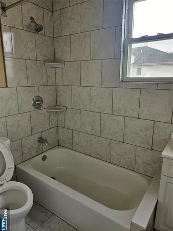 a white bath tub sitting next to a toilet