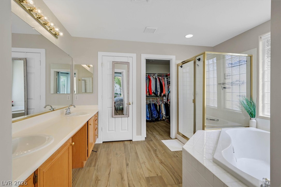 1259 Moon Vision Street Henderson, NV 89052 - Photo 19 of 53 Indulge in this primary bathroom featuring a generous soaking tub, dual vanities, and a convenient walk-in closet.