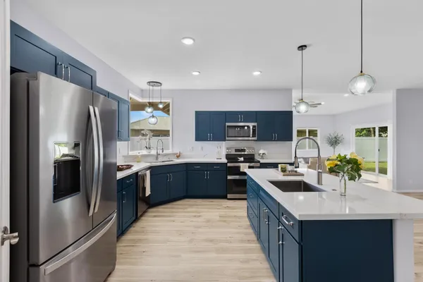 a large kitchen with a large counter top sink and refrigerator
