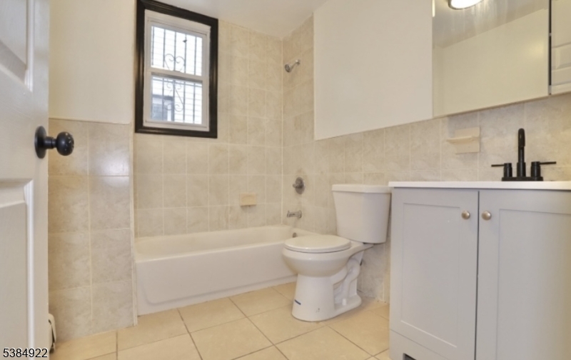 445 South 15th Street Newark, NJ 07103 - Photo 5 of 5 a bathroom with a toilet a sink a window and shower