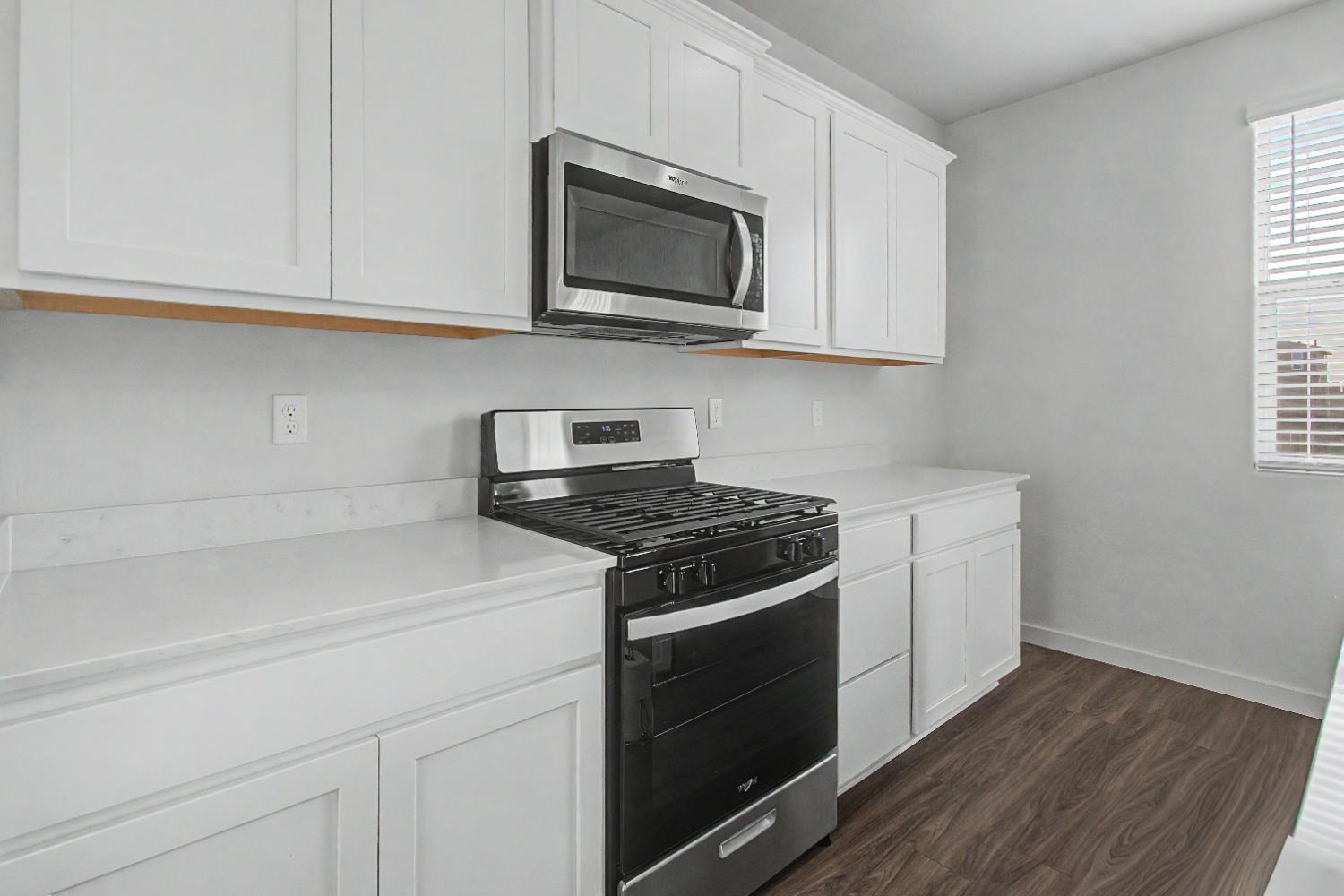4119 Anise Court Merced, CA 95348 - Photo 7 of 27 a kitchen with stainless steel appliances granite countertop white cabinets a microwave a sink and a refrigerator